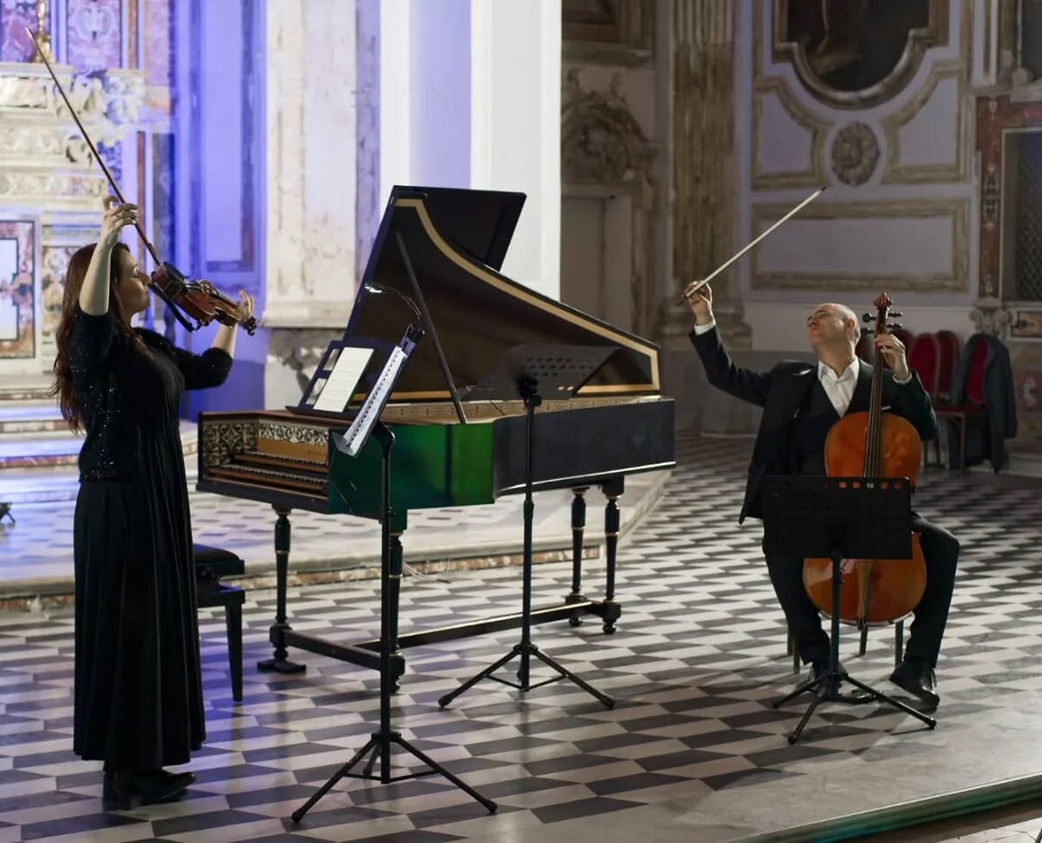 Docente di musica barocca che segue studenti durante una masterclass